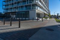 an empty road with concrete poles on both sides of it and buildings in the background