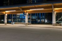 an empty parking lot filled with lots of lights at night time near a city street