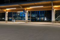 an empty parking lot filled with lots of lights at night time near a city street