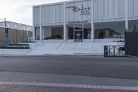 a white store with stairs and a sign that says rode cafe on it's front