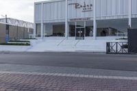 a white store with stairs and a sign that says rode cafe on it's front