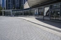 a person sitting at the bench in front of a mall that is empty of people