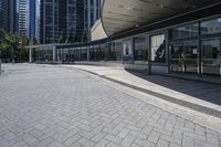 a person sitting at the bench in front of a mall that is empty of people