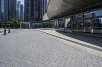 a person sitting at the bench in front of a mall that is empty of people