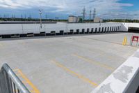 a parking lot in an industrial building with several yellow lines and white columns on it