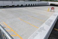 a parking lot in an industrial building with several yellow lines and white columns on it