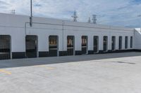 empty parking area with large industrial building in the background that has no cars in front of it