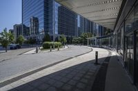 a person sitting at the bench in front of a mall that is empty of people