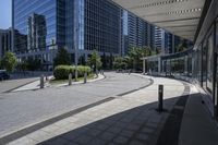 a person sitting at the bench in front of a mall that is empty of people