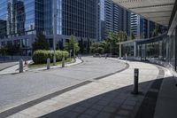 a person sitting at the bench in front of a mall that is empty of people