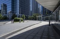 a person sitting at the bench in front of a mall that is empty of people