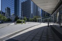 a person sitting at the bench in front of a mall that is empty of people