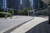 a person sitting at the bench in front of a mall that is empty of people