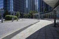 a person sitting at the bench in front of a mall that is empty of people