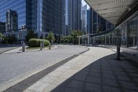 a person sitting at the bench in front of a mall that is empty of people