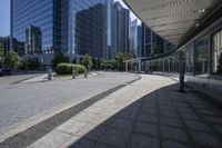 a person sitting at the bench in front of a mall that is empty of people