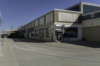 a building is in the middle of a cement parking lot, which has a large hole on the floor