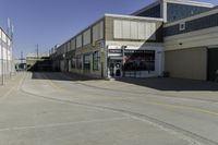 a building is in the middle of a cement parking lot, which has a large hole on the floor