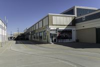 a building is in the middle of a cement parking lot, which has a large hole on the floor