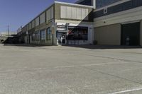 a building is in the middle of a cement parking lot, which has a large hole on the floor