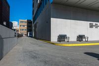 a sidewalk and benches are painted white and yellow to match the rest of a long city street