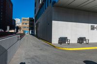 a sidewalk and benches are painted white and yellow to match the rest of a long city street