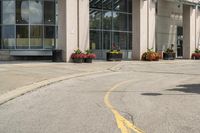 a paved city street with a yellow line down the middle of it and two people riding motorcycles in front