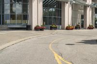 a paved city street with a yellow line down the middle of it and two people riding motorcycles in front