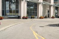 a paved city street with a yellow line down the middle of it and two people riding motorcycles in front