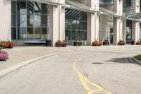 a paved city street with a yellow line down the middle of it and two people riding motorcycles in front