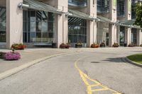 a paved city street with a yellow line down the middle of it and two people riding motorcycles in front