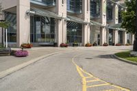 a paved city street with a yellow line down the middle of it and two people riding motorcycles in front