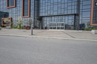 an industrial building is sitting on the street corner with concrete pavement and parking meters below it