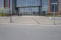 an industrial building is sitting on the street corner with concrete pavement and parking meters below it