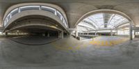 a picture looking down an indoor parking structure, with a train running underneath it and on the ground behind