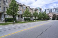 a car is driving along the side of a street on a sunny day with residential homes in the background