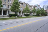 a car is driving along the side of a street on a sunny day with residential homes in the background