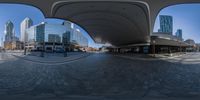 360 - lens shot looking into a plaza full of buildings and a clock tower in the distance