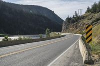 a long and winding road runs in the mountains under blue skies with bright clouds overhead