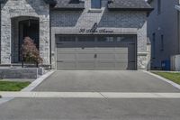 two story brick home with garage and three car garage doors and front window well maintained by large trees, flower pots, and landscaping