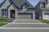 two story brick home with garage and three car garage doors and front window well maintained by large trees, flower pots, and landscaping