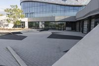 a view of an outside area of an office building with large windows and a circular driveway