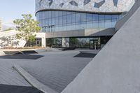 a view of an outside area of an office building with large windows and a circular driveway