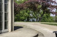 a trash can near the side of some steps by water with trees in background and buildings along the edge