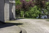 a trash can near the side of some steps by water with trees in background and buildings along the edge