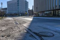 a sidewalk along the side of the road that has buildings and a sky line behind them