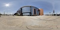 a fish eye lens view of a modern building at the end of a driveway, surrounded by a circle shaped path