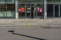 a street sign in front of a glass shop front with many parking spaces in it