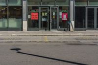 a street sign in front of a glass shop front with many parking spaces in it