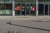 a street sign in front of a glass shop front with many parking spaces in it